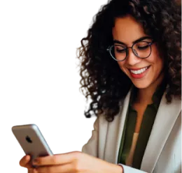 Mulher de pele retita, de cabelos cacheados e escuros, usando um óculo de armação redonda, sorrindo. Usa um blazer de cor bege e segura um celular com as mãos